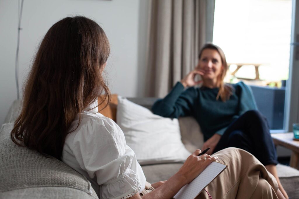 Daphne Maierna in conversation with a client on a sofa